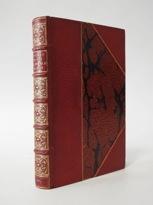 an old book with a red cover and gold trim on it