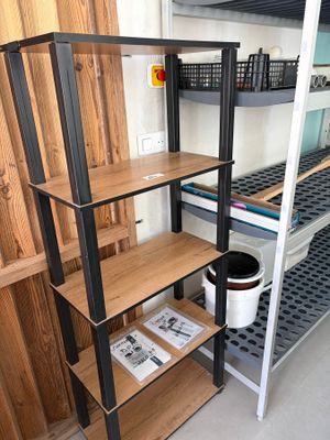 une étagère avec des tablettes et un seau posé par terre