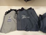 three pairs of pants sitting on a table next to a purse