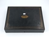 an old black box with a gold medallion on the lid