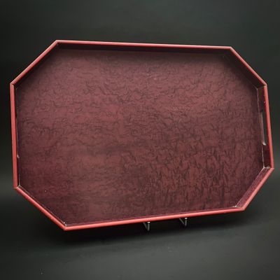 une image représentant un plateau rouge posé sur une table noire