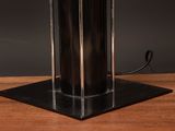a black lamp that is on top of a wooden table