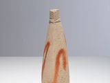 a small bottle with graffiti on it sitting on a table
