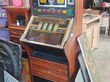 une machine à sous à l'ancienne dans un garage, parmi de nombreux autres objets
