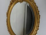 un miroir doré accroché au mur à côté d'une porte