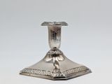 an antique silver plated candle holder on a white background