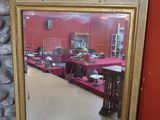 un miroir posé sur le sol devant un mur rouge