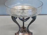 un saladier en verre posé sur un support, sur une table