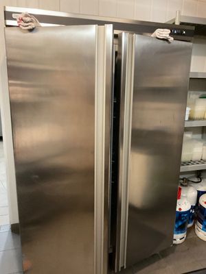 a stainless steel refrigerator in a kitchen next to a counter