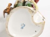 porcelain figurine of a bird with a basket of fruit on its back