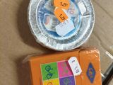 une boîte d'oranges et une assiette en plastique sur laquelle est accrochée une étiquette de prix
