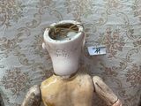 a wooden doll that has a cup on its head