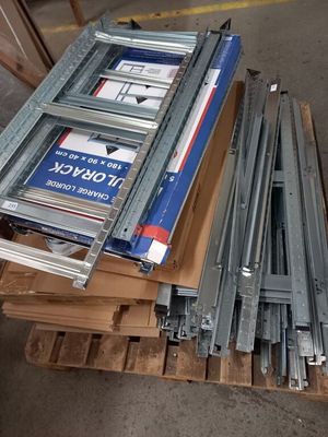 une pile de rails métalliques posée sur une palette dans un entrepôt