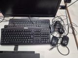 a computer keyboard and mouse on a desk with a monitor