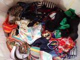 a basket full of clothes that is sitting on a bed