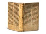 un vieux livre écrit posé sur une surface blanche