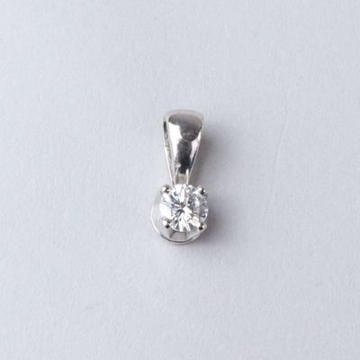 a close up of a diamond pendant on a white surface