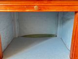a wooden cabinet with a drawer on top of it