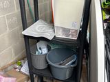 a black shelf with a white refrigerator and a black trash can in it