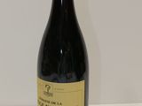 une bouteille de vin rouge posée sur une table blanche