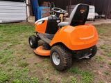 an orange ride on lawn mower parked in a yard