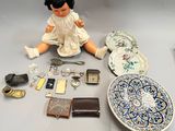 a doll that is sitting on the ground next to a plate