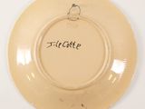 a yellow plate with a bird on it with a name written on it