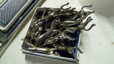 un récipient en métal rempli de figurines en argent, posé sur un comptoir
