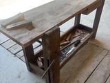 une table en bois sur laquelle sont posés des outils, dans un garage