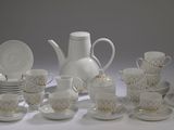 un grand nombre de tasses et de soucoupes posées sur une table