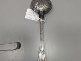 a close up of a spoon with a tag on it on a table