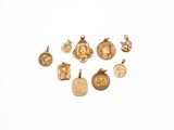 a close up of a group of gold charms on a white surface