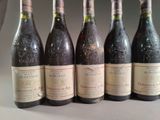 six bottles of wine are lined up in a row on a table