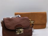 brown and brown purses sitting next to each other on a white surface