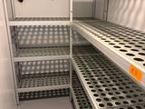 une étagère métallique surmontée d'un ventilateur, dans une pièce