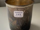 a silver cup sitting on a table with a price tag on it