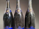 trois bouteilles de champagne posées côte à côte sur une table