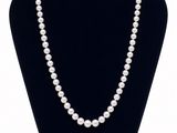 un collier de perles blanches sur un mannequin noir