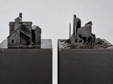 une paire de sculptures métalliques représentant des bâtiments et un cheval dans un champ