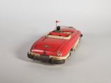 a red toy car with a flag on top of it