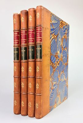 trois livres sont empilés sur une surface blanche