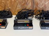 Quatre appareils électroniques sont alignés sur une table blanche