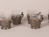 four glass vases are lined up in a row on a white surface