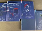 four books with pictures of people on them sitting on a table