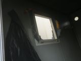 a picture of a bathroom with a window and a trash bag