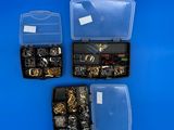 trois boîtes contenant différents types de bijoux, posées sur un fond bleu