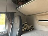 a bed in the back of a van with a window open