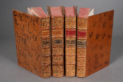 three old books sitting on top of each other on a table