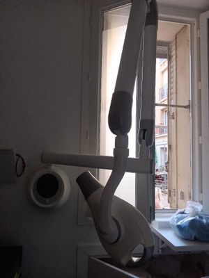 un fauteuil de dentiste devant une fenêtre, dans une pièce