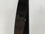 une sculpture représentant un bateau, de couleur noire et marron, posée sur une surface blanche